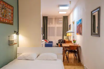 a bedroom with a bed and a dining room at Stylish Private Studio Close to City in Amsterdam
