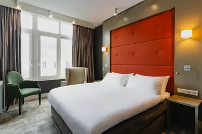 a hotel room with a bed and a chair at Hotel JL No76 in Amsterdam