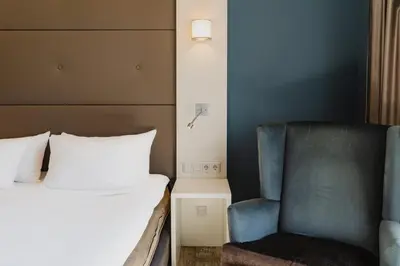 a bedroom with a bed and a chair at Hotel JL No76 in Amsterdam