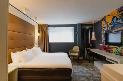 a hotel room with a bed and a flat screen tv at Hotel JL No76 in Amsterdam