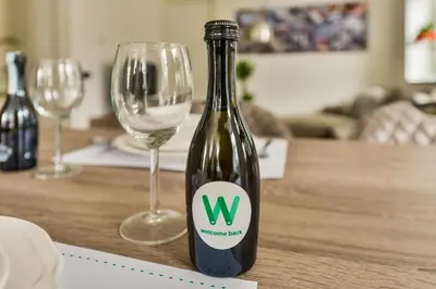 a bottle of wine on a table with two wine glasses at Luxury Family Residence Schinkeldijkje in Aalsmeer