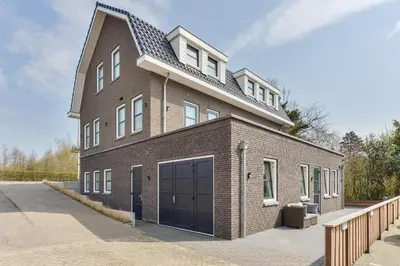 a large brick building with a large garage at Luxury Family Residence Schinkeldijkje in Aalsmeer