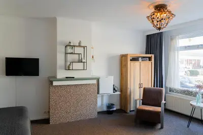 a hotel room with a desk and a chair and a window at Boutique Lodge Zandvoort in Zandvoort