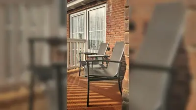 a row of chairs on a balcony with a window at Boutique Lodge Zandvoort in Zandvoort