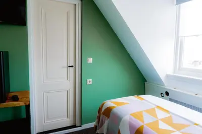 a bedroom with green walls and a white door at Boutique Lodge Zandvoort in Zandvoort