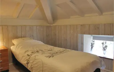 a bed in a room with a wooden wall at Penhuis in Winkel