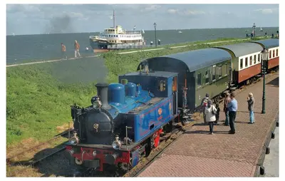 a train on the tracks with people standing next to it at Penhuis in Winkel