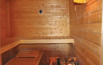 a sauna with a bench in a wooden wall at Penhuis in Winkel