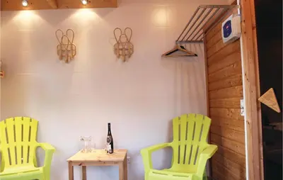 two yellow chairs and a table with a bottle of wine at Penhuis in Winkel