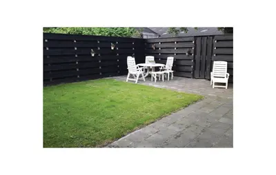 a backyard with a table and chairs and a fence at Penhuis in Winkel