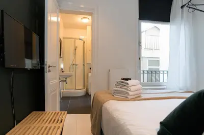 a room with a bed and a bathroom with a shower at Canal Suite City Centre in Amsterdam
