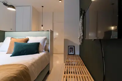 a bedroom with a bed with a wooden bench next to it at Canal Suite City Centre in Amsterdam