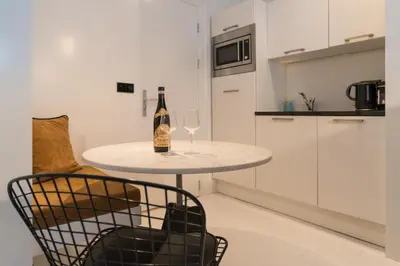 a table with a bottle and two glasses of wine at Canal Suite City Centre in Amsterdam