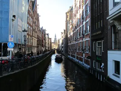 a boat in a canal in a city with buildings at City Break Amsterdam in Amsterdam