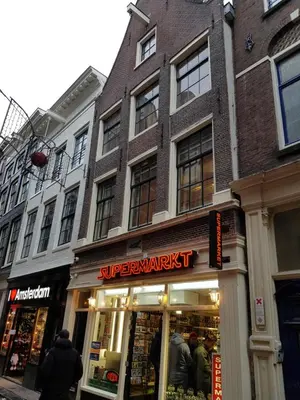 a store front of a building with people standing outside at City Break Amsterdam in Amsterdam