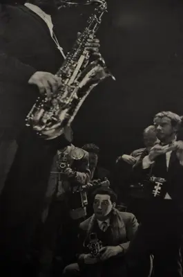 a man playing a saxophone in a crowd of people at The Concert Hotel in Amsterdam