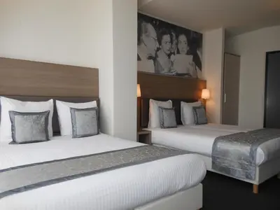 a hotel room with two beds and a picture on the wall at The Concert Hotel in Amsterdam
