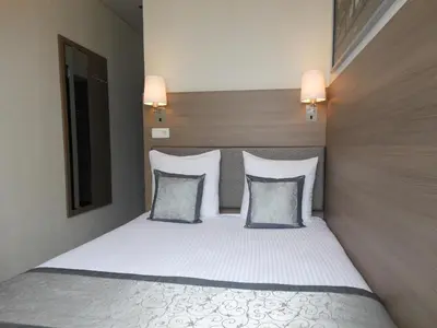 a bedroom with a bed with white sheets and pillows at The Concert Hotel in Amsterdam
