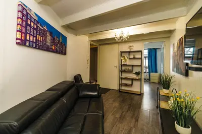 a living room with a black leather couch at City Heart Station Amsterdam in Amsterdam