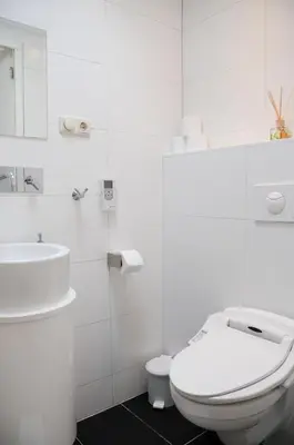 a white bathroom with a toilet and a sink at Boathotel in Amsterdam