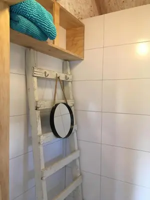 a mirror on a shelf in a bathroom at Groeten uit Hoogmade - rural cottage in Hoogmaden