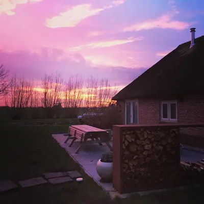 a house with a picnic table in the yard at Groeten uit Hoogmade - rural cottage in Hoogmaden