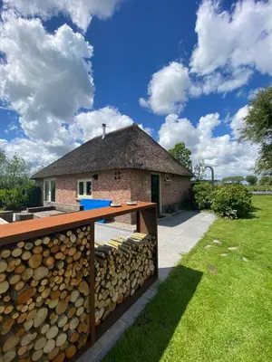 a stack of firewood in front of a house at Groeten uit Hoogmade - rural cottage in Hoogmaden