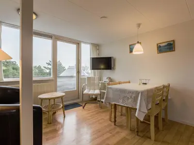 a dining room with a table and chairs and a window at Apartment in North Holland in Bergen aan Zee
