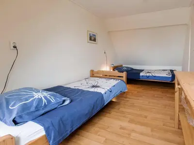 a bedroom with two beds and a wooden floor at Apartment in North Holland in Bergen aan Zee