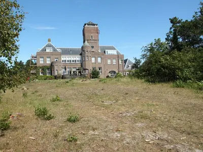 an old building on top of a grass field at Apartment in North Holland in Bergen aan Zee