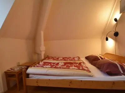 a bed in a room with avertisementatronatronstrationstrationstrationstration at Apartment in Bergen aan Zee near the Beach in Bergen aan Zee