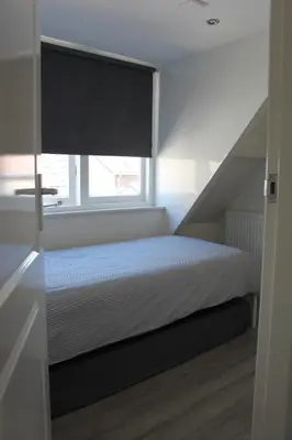 a bedroom with a bed with a window and a bedspread at Viale in Egmond aan Zee