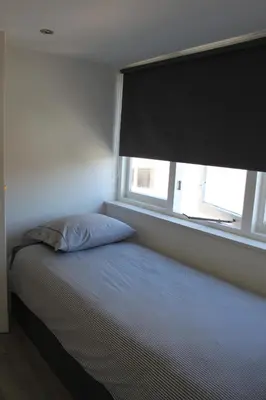 a bed in a room with a large window at Viale in Egmond aan Zee