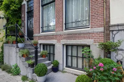 a brick building with stairs and potted plants on it at SeventyFive in Amsterdam