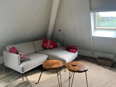 a living room with a couch and two tables at Gastenverblijf Eenigenburg in Eenigenburg