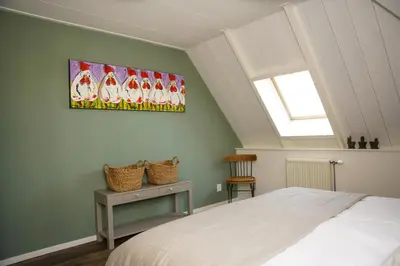 a bedroom with a bed and a painting on the wall at Gastenverblijf Eenigenburg in Eenigenburg
