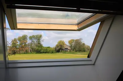 a window in a room with a view of a house at Gastenverblijf Eenigenburg in Eenigenburg