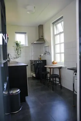 a kitchen with a table and a sink and a table at Gastenverblijf Eenigenburg in Eenigenburg