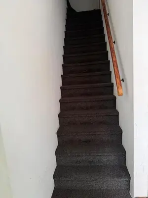 a stairway with a wooden hand rail and a stair case at Koningshof XL in Alkmaar