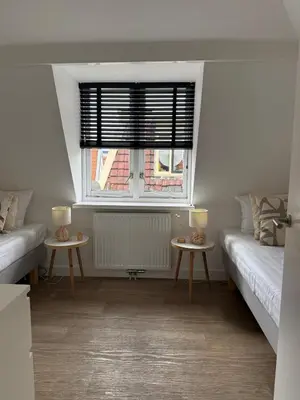 a living room with two tables and a window at Koningshof XL in Alkmaar