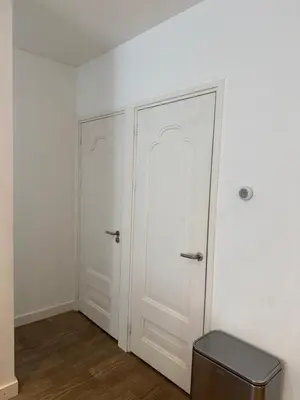 a room with two white doors and a stool at Koningshof XL in Alkmaar