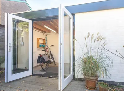 an open door to a patio with a bike at holiday cottage 'FLOW' in Bergen