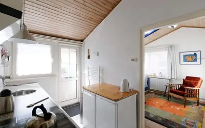 a kitchen with white walls and a wooden ceiling at holiday cottage 'FLOW' in Bergen
