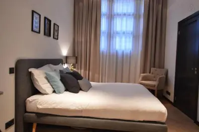 a bedroom with a bed with pillows and a window at Romantic ground floor suite in Pijp near Sarphatipark in Amsterdam