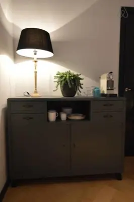 a table with a lamp and a potted plant on it at Romantic ground floor suite in Pijp near Sarphatipark in Amsterdam