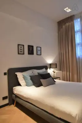 a bedroom with a bed with pillows and a window at Romantic ground floor suite in Pijp near Sarphatipark in Amsterdam