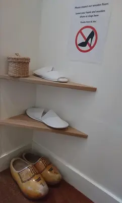 a pair of shoes and a sign on a shelf at Huis Roomolen in Amsterdam