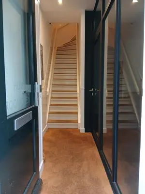 a hallway with glass doors and stairs in a house at Huis Roomolen in Amsterdam