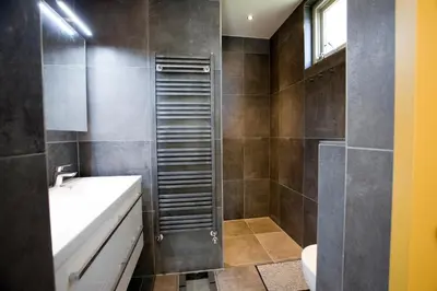 a bathroom with a shower and a toilet and a sink at B&B PeperZzz in Bergen