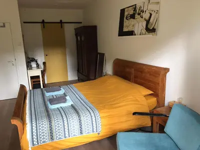 a bedroom with a bed and a blue chair at B&B PeperZzz in Bergen